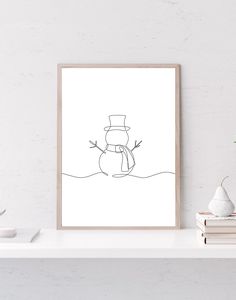 a black and white drawing of a snowman on a shelf next to some books