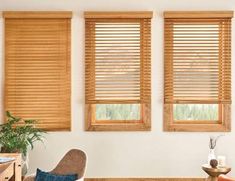 the living room has three windows with wooden blinds on them and a chair in front of it