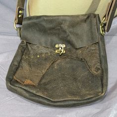 This large shoulder bag is made using scrap leather from other projects, riveted together to make interesting patterns. Sized to fit tablets, phones, wallets, and more, this unique bag is sure to catch the eye. Roughly 11" (28am) tall x 9" k23cm) wide, with a 2" (5cm) gusset. Leather Tote Shoulder Bag With Hardware, Daily Use Satchel With Hardware As Shoulder Bag, Daily Use Satchel With Shoulder Bag Shape And Hardware, Leather Tote Bag With Hardware Details, Rugged Satchel Shoulder Bag With Leather Backing, Leather Tote Satchel With Cell Phone Pocket, Vintage Leather Bags With Hardware Details, Brown Bags With Hardware For Daily Use, Rugged Rectangular Shoulder Bag With Adjustable Strap