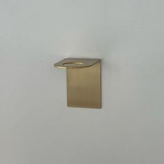 a gold square shaped object on a white wall