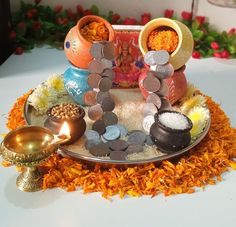 an assortment of coins and other items on a platter with flowers in the background