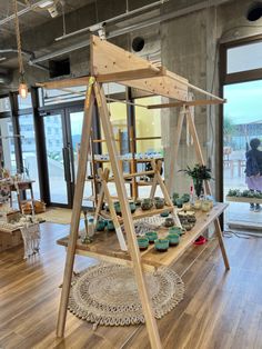 a wooden display case with green cupcakes on it in front of a window