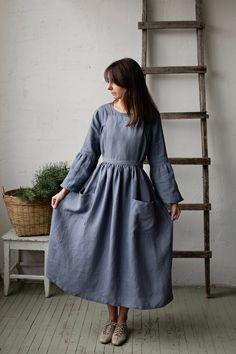 "Long cross back pinafore is made from 100% soft and washed linen.  Details: - Colour: Dusty blue - Composition: 100% Oeko-Tex certified linen - Cross back - Adjustable with buttons - Size: One size - Medium weight linen - Linen care: machine wash gentle; tumble dry low, ironing optional - The price is for one pinafore dress, other pictured items are not included The model is 170 cm/5'7\" and wears a size one size." Linen Pinafore, Apron Cooking, Apron For Women, Apron Kitchen, Womens Aprons, Cooking Apron, Pinafore Dress, Linen Apron, Style Expert