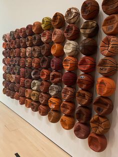 several basketballs are hanging on the wall next to each other