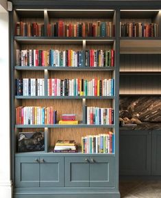 a bookshelf filled with lots of books next to a wall covered in shelves