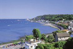 an aerial view of the ocean with houses and boats in the water near shore line