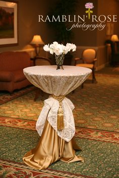 a table with white flowers on it in a hotel lobby area at the rambling rose photography