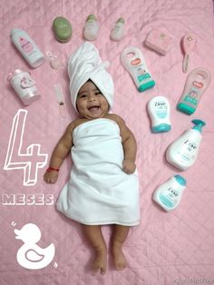 a baby laying on top of a pink blanket next to lots of personal care items