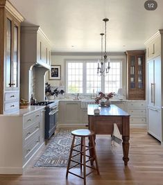 a large kitchen with an island in the middle and two stools next to it