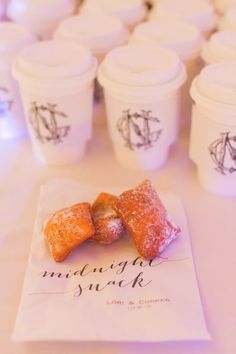 pastries are sitting on top of a napkin next to cups