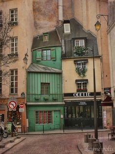 an old building with green shutters and windows