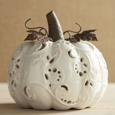 a decorative white pumpkin sitting on top of a table