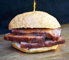 a close up of a sandwich on a wooden table with a toothpick sticking out of it