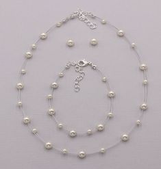 "Perfect for that adorable little girl, this necklace and earrings set features high lister glass pearls and matching Swarovski stud pearl earrings. Necklace is adjustable measuring 12\"-14\" long. Made with durable silver tone cording in a unique \"floating\" design. Choose from four pearl colors. Matching bracelet measures 6 1/2\" and has an extender for additional length. Can be created on a custom jewelry card with your choice of name and font color! All jewelry features high quality electro Pearl Charm Jewelry For First Communion, Elegant Pearl White Jewelry For First Communion, Adjustable Round White Jewelry Sets, White Pearl Jewelry Sets With Pearl Chain, White Pearl Charm Jewelry For First Communion, Adjustable Round Pearl Jewelry Sets, White Hypoallergenic Pearl Necklace, Hypoallergenic White Pearl Necklace, Adjustable Pearl Jewelry Sets For Gift