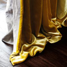 yellow and white curtains are lined up on the floor in front of a wooden floor