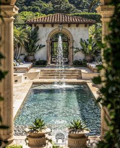 an outdoor fountain surrounded by potted plants