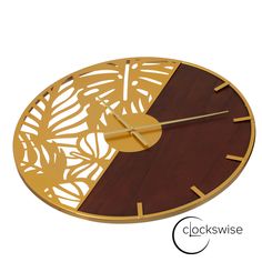 a clock that is made out of wood and has leaves on the face with gold hands