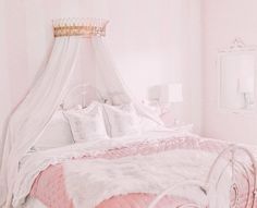 a white bed topped with pink and white pillows