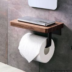 a toilet paper roll is hanging on the wall next to a cell phone and mirror