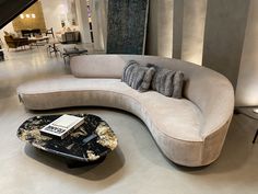 a curved couch with pillows on it in a living room