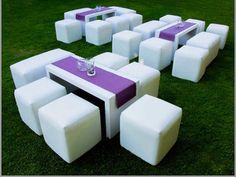 a table and chairs made out of white cubes on the grass with purple accents