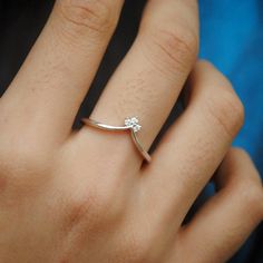 a close up of a person's hand with a diamond ring on their finger