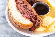 a corned beef sandwich and french fries on a white plate with a side of ketchup