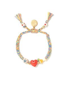 the beaded bracelet has a heart, bell and tasseled charms on it