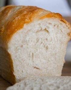 a loaf of white bread sitting on top of a wooden table