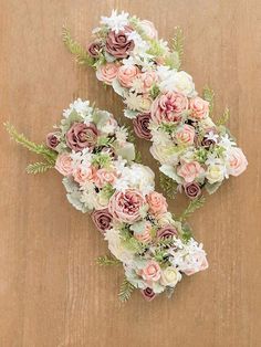 two bouquets of flowers sitting on top of a wooden table