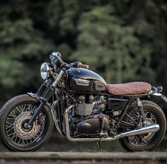 a black motorcycle parked in front of some trees