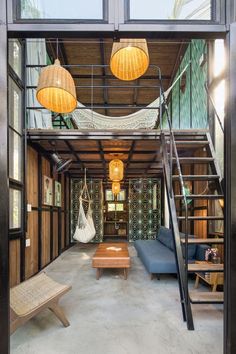 the inside of a house with lots of wood and glass on the walls, stairs to the second floor