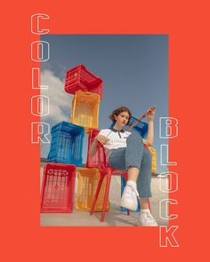 a woman sitting on top of a red chair in front of colorful plastic crates with the words color block