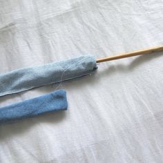 an umbrella is laying on top of a bed with blue fabric and a wooden stick