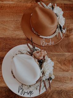 two hats with name written on them sitting on top of a wooden floor next to each other