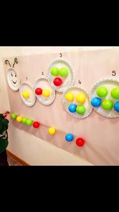 a child is standing in front of a wall with candy