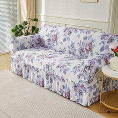 a living room with a floral couch and coffee table on the floor next to it