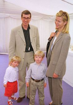 a man, woman and two children standing in front of a purple carpeted floor