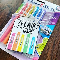 some pens and markers are sitting on a table with a tag that says, what's little flair to start the year right?