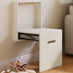 a pair of shoes are sitting on the floor next to a white shoe box and shelf