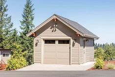 two garages with one attached to the side of it and trees in the background