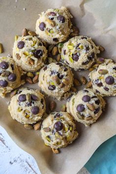 chocolate chip cookies with pistachios and almonds on parchment paper, ready to be eaten