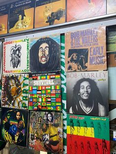 there are many different records on display in the store front window, including bob marley's album covers