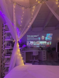 a bedroom with purple lights on the ceiling and a white bed covered in mosquito netting