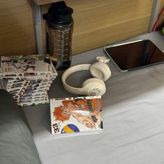 headphones, mp3 player and magazine on a table next to a cell phone in front of a mirror