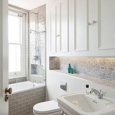 a bathroom with a toilet, sink and bathtub next to a window in it