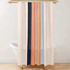 a shower curtain with multicolored curtains hanging on a gold rod in front of a white bathtub