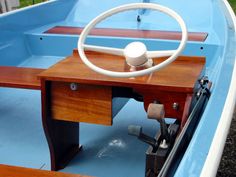 the steering wheel on a small blue boat