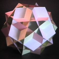 an origami sculpture is displayed on a black surface with white squares and pink rectangles