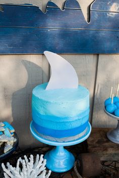 a blue cake sitting on top of a table